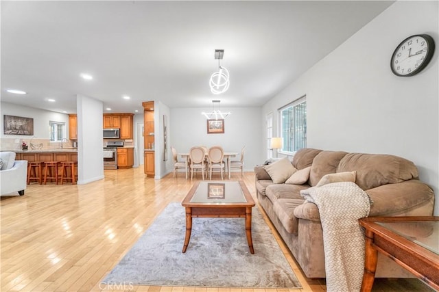 living area featuring a chandelier, recessed lighting, and light wood-style floors