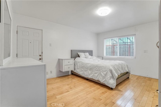 bedroom with light wood-style flooring and baseboards