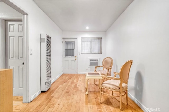 interior space featuring baseboards, a heating unit, light wood-type flooring, a wall mounted AC, and recessed lighting