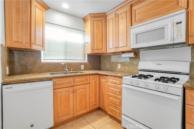 kitchen with light tile patterned floors, a sink, tasteful backsplash, and white appliances