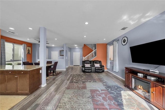 living room featuring stairway, wood finished floors, visible vents, and recessed lighting