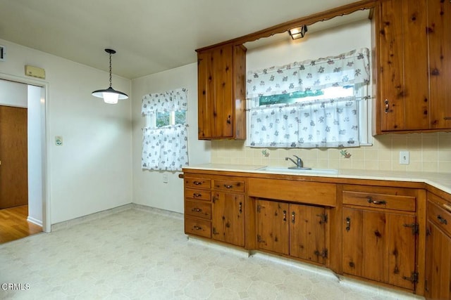 kitchen featuring hanging light fixtures, sink, and decorative backsplash