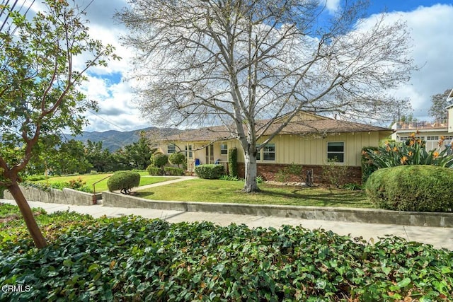 view of front of house featuring a mountain view and a front yard