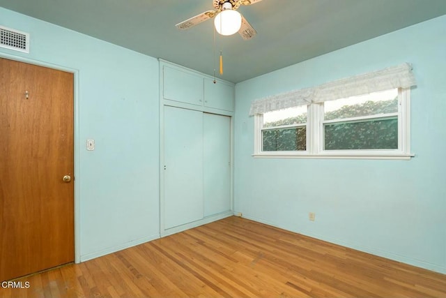 unfurnished bedroom with light hardwood / wood-style floors, a closet, and ceiling fan