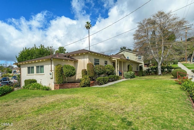 view of front of home with stucco siding and a front yard