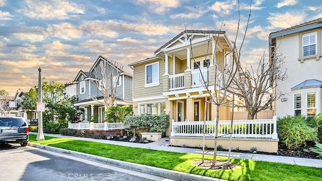 view of front of home with a lawn and a balcony