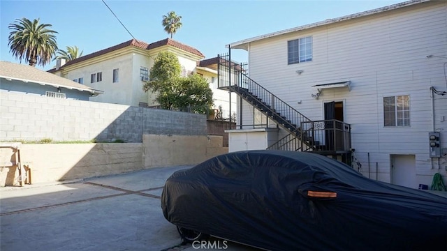 exterior space featuring fence, stairway, and a patio