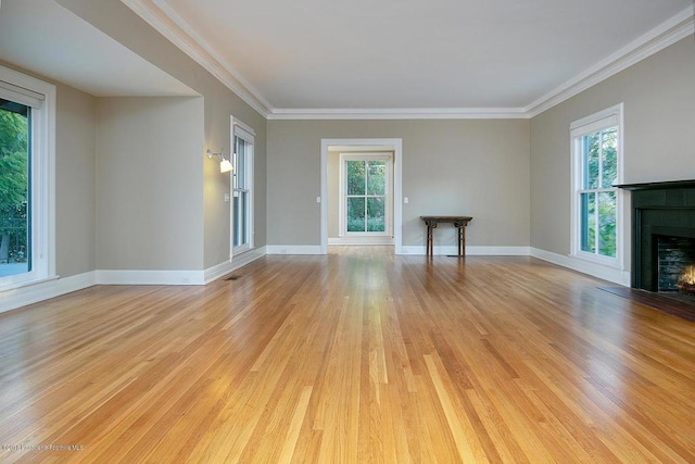 unfurnished living room featuring light wood finished floors, visible vents, baseboards, crown molding, and a brick fireplace