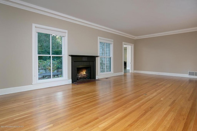 unfurnished living room featuring a fireplace with flush hearth, visible vents, ornamental molding, and baseboards