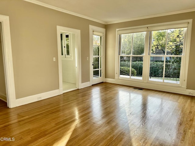 interior space with crown molding, baseboards, and wood finished floors