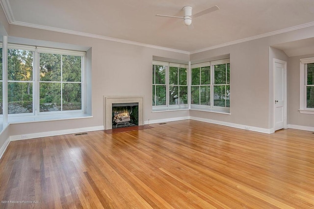 unfurnished living room featuring plenty of natural light, light wood-style floors, a fireplace with flush hearth, and visible vents