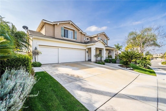 view of front facade with a garage, driveway, and stucco siding