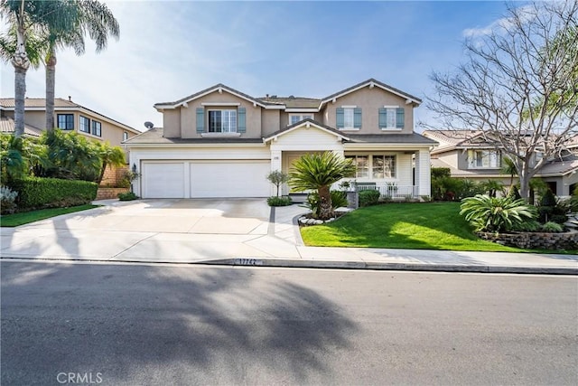 view of front of home featuring a front lawn, concrete driveway, an attached garage, and stucco siding