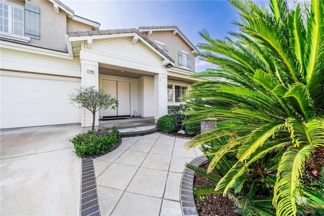 property entrance featuring a tile roof and driveway