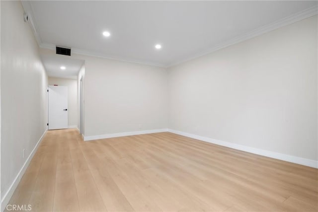 spare room featuring ornamental molding and light hardwood / wood-style floors