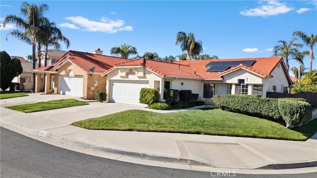 mediterranean / spanish-style home with solar panels, a chimney, concrete driveway, and a tiled roof