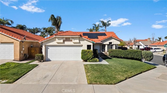 mediterranean / spanish home with driveway, solar panels, a tiled roof, an attached garage, and stucco siding