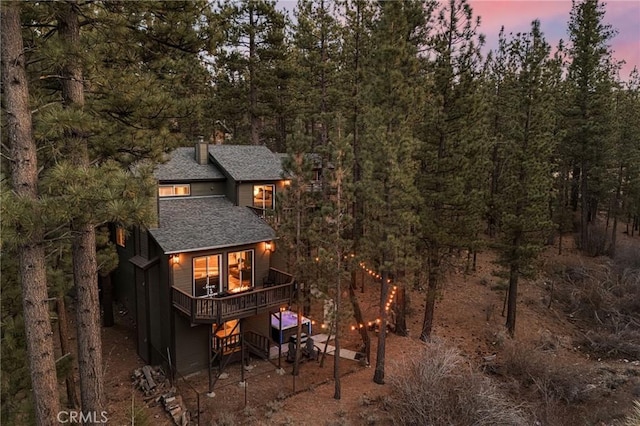 back house at dusk with a deck