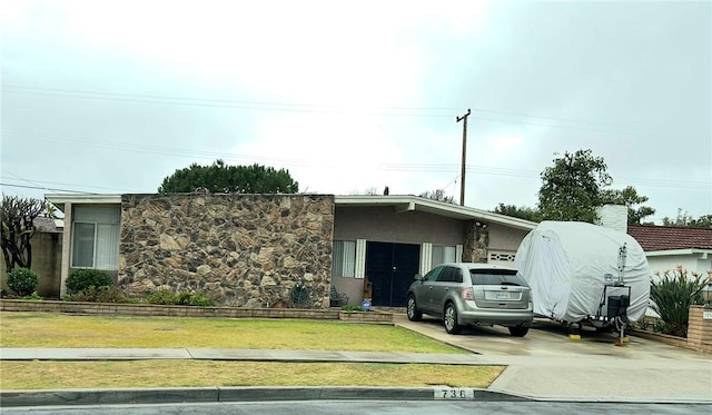 view of front of home with stucco siding, concrete driveway, and a front yard