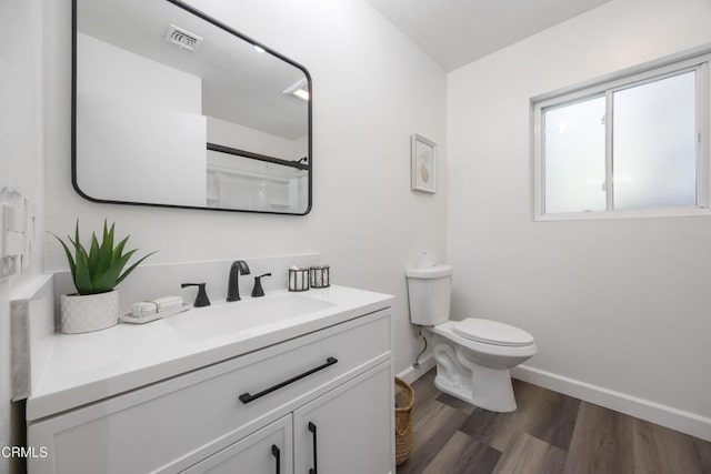 bathroom with toilet, vanity, walk in shower, and wood-type flooring