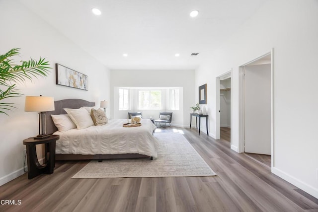 bedroom featuring hardwood / wood-style flooring and a walk in closet