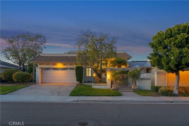 view of front facade featuring a garage, concrete driveway, and stucco siding