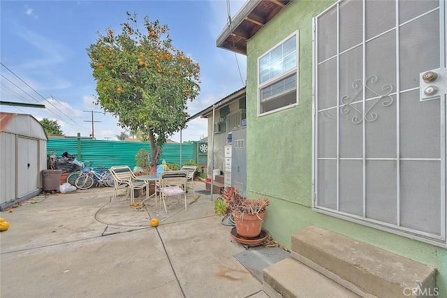 946 E J St, Ontario, CA 91764 - view of patio with a shed, an outbuilding, a fenced backyard, and outdoor dining area