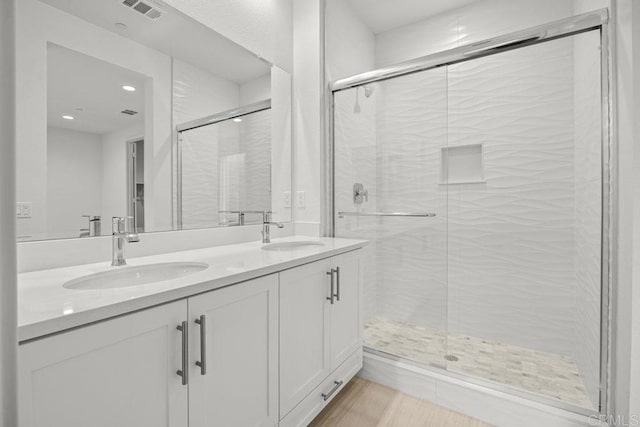 bathroom featuring a sink, visible vents, and a shower stall