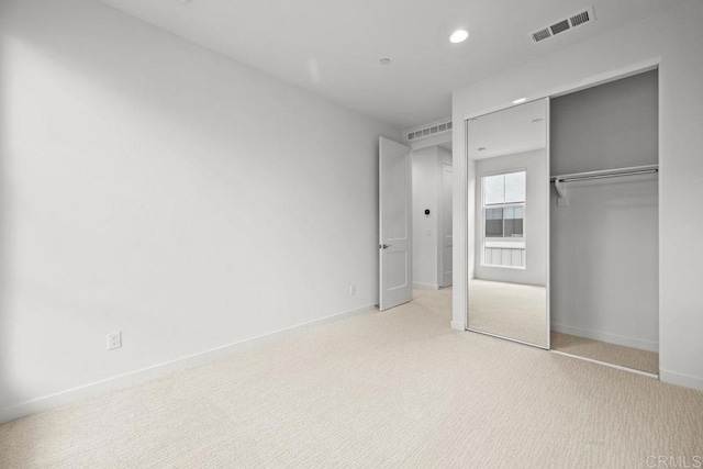 unfurnished bedroom featuring visible vents, baseboards, a closet, carpet floors, and recessed lighting
