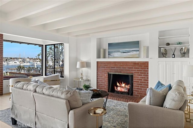 living room with a brick fireplace, a water view, built in features, and beam ceiling