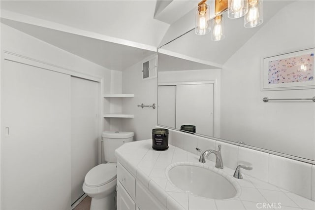 bathroom featuring vanity, vaulted ceiling, and toilet