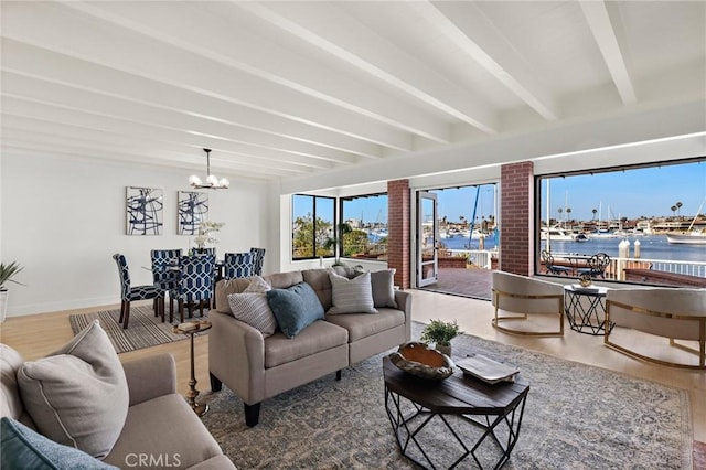 living room featuring hardwood / wood-style flooring, beamed ceiling, a water view, and an inviting chandelier