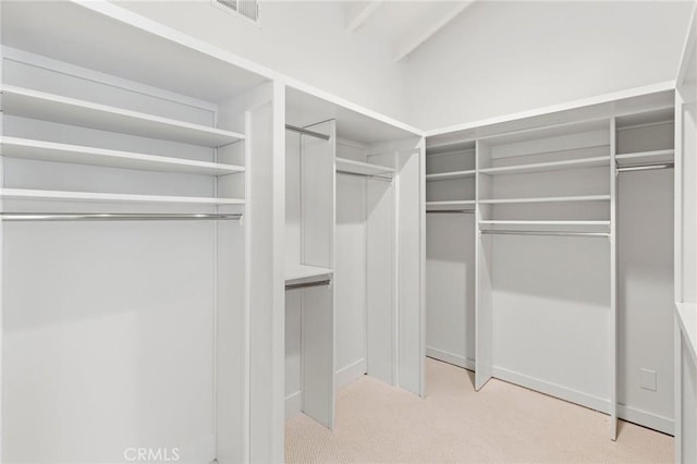 walk in closet featuring light carpet