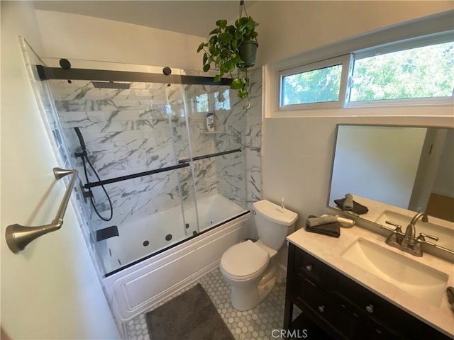bathroom featuring vanity, bath / shower combo with glass door, tile patterned floors, and toilet