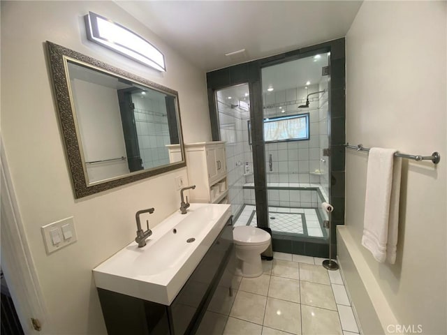 full bath featuring toilet, a shower stall, a sink, and tile patterned flooring