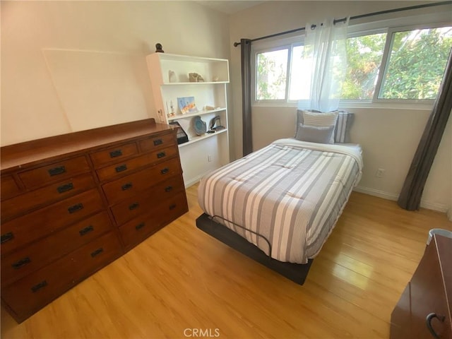 bedroom with light wood-style floors and baseboards