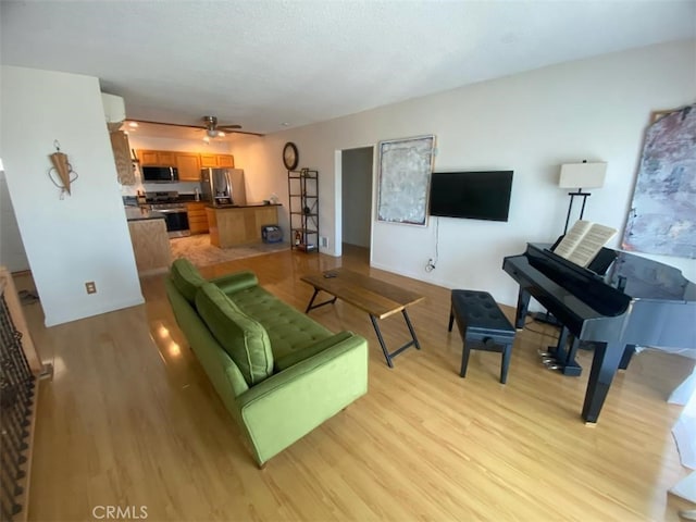 living area featuring ceiling fan and light wood-style floors