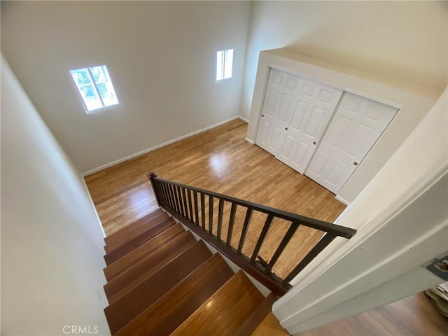 staircase featuring baseboards and wood finished floors
