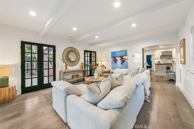 living area featuring french doors, recessed lighting, light wood-style flooring, beamed ceiling, and baseboards