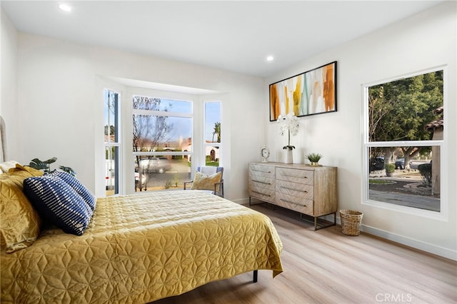 bedroom featuring multiple windows, baseboards, wood finished floors, and recessed lighting