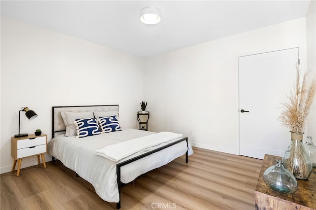 bedroom featuring light wood-style flooring and baseboards