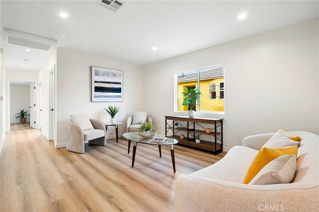 living area with light wood finished floors, baseboards, visible vents, and recessed lighting