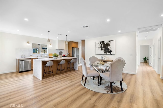 dining room featuring baseboards, light wood-style flooring, visible vents, and recessed lighting