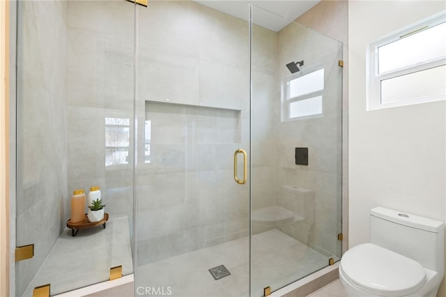 bathroom featuring toilet and a shower stall