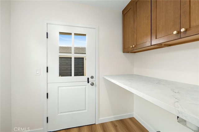 entryway with baseboards and light wood finished floors