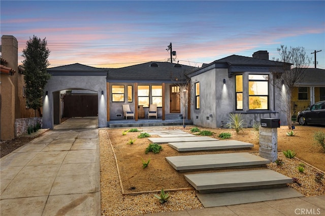 view of front of home with an attached garage, concrete driveway, and stucco siding