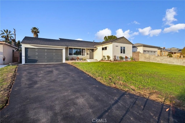 ranch-style house featuring a garage and a front lawn