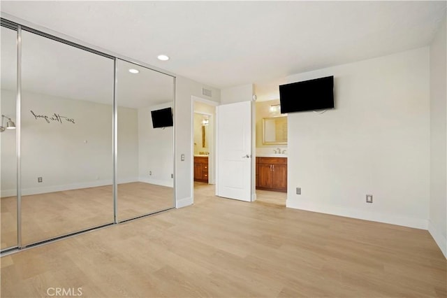 unfurnished bedroom with visible vents, baseboards, ensuite bath, light wood-type flooring, and recessed lighting