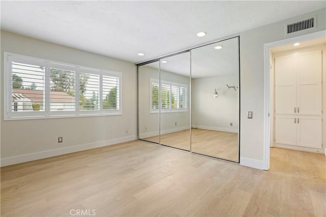 unfurnished bedroom with recessed lighting, visible vents, baseboards, light wood-style floors, and a closet