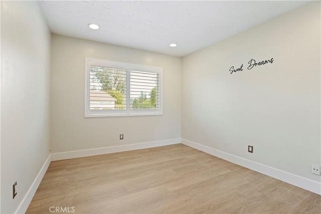 unfurnished room with light wood-style floors, recessed lighting, and baseboards